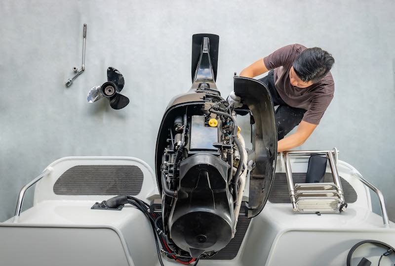 Man working on his 4 stroke out boat motor