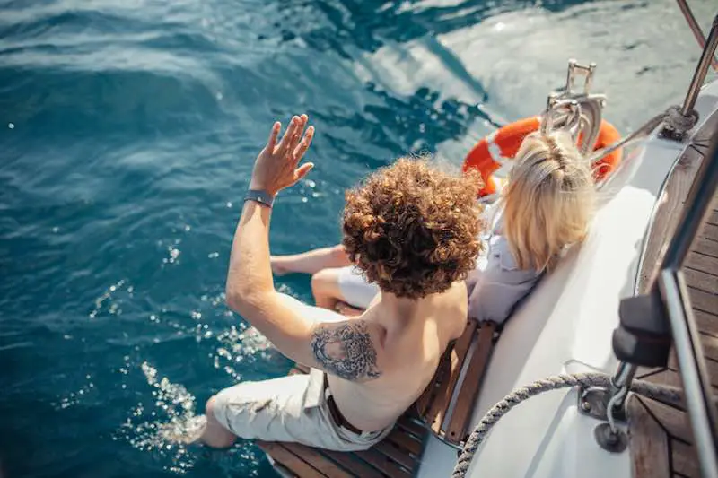 Couple enjoying life on a boat with their feet in the water. Personal hygiene