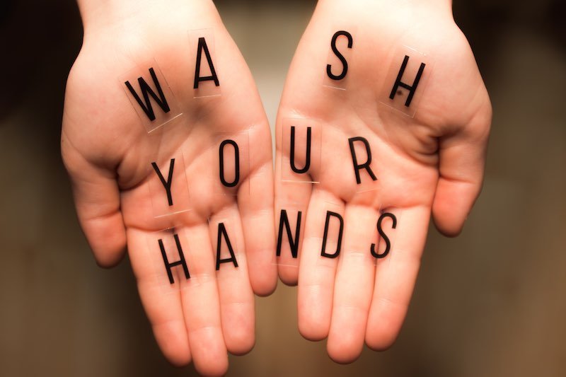 Wash hands message written on palms
